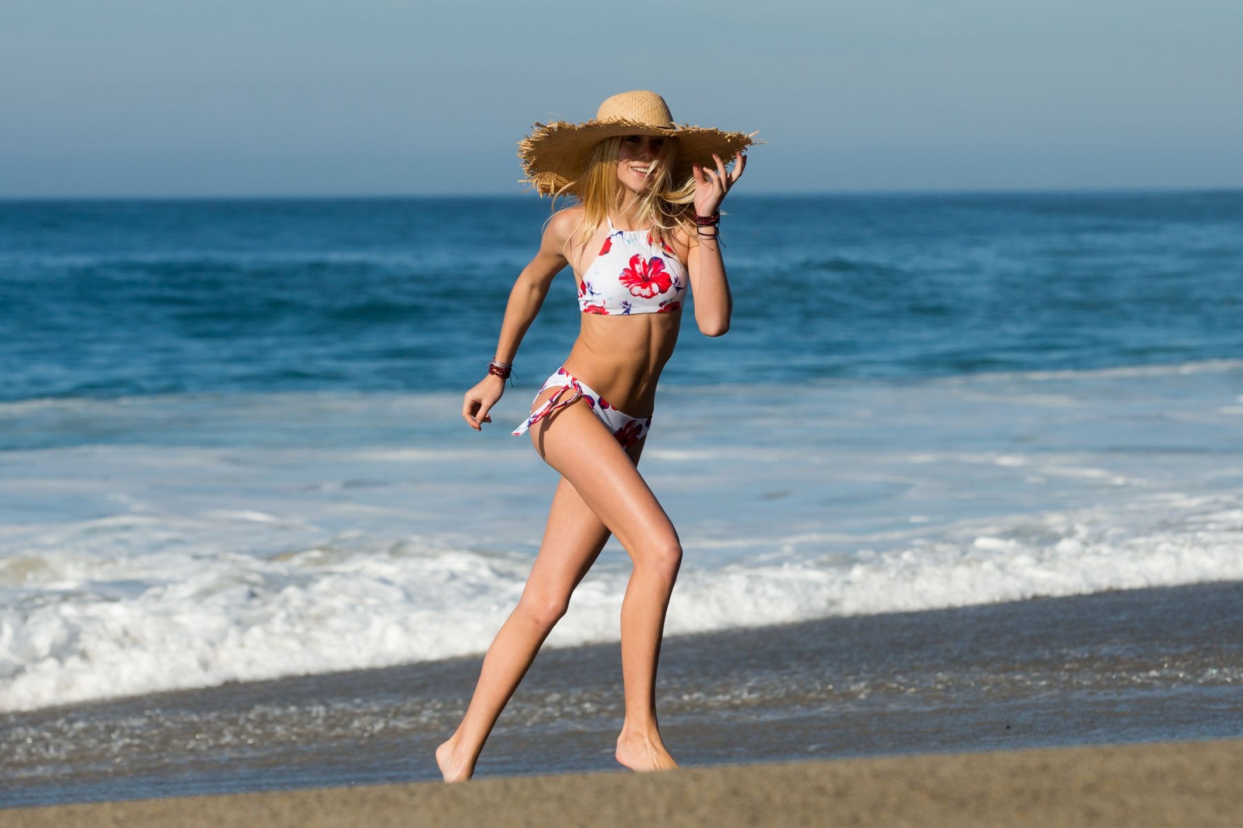 Girl Running on the beach in her Red floral Aloha Spirit Halter Top Bikini Set for Tween and Teen Girs, made by Chance Loves Swimwear
