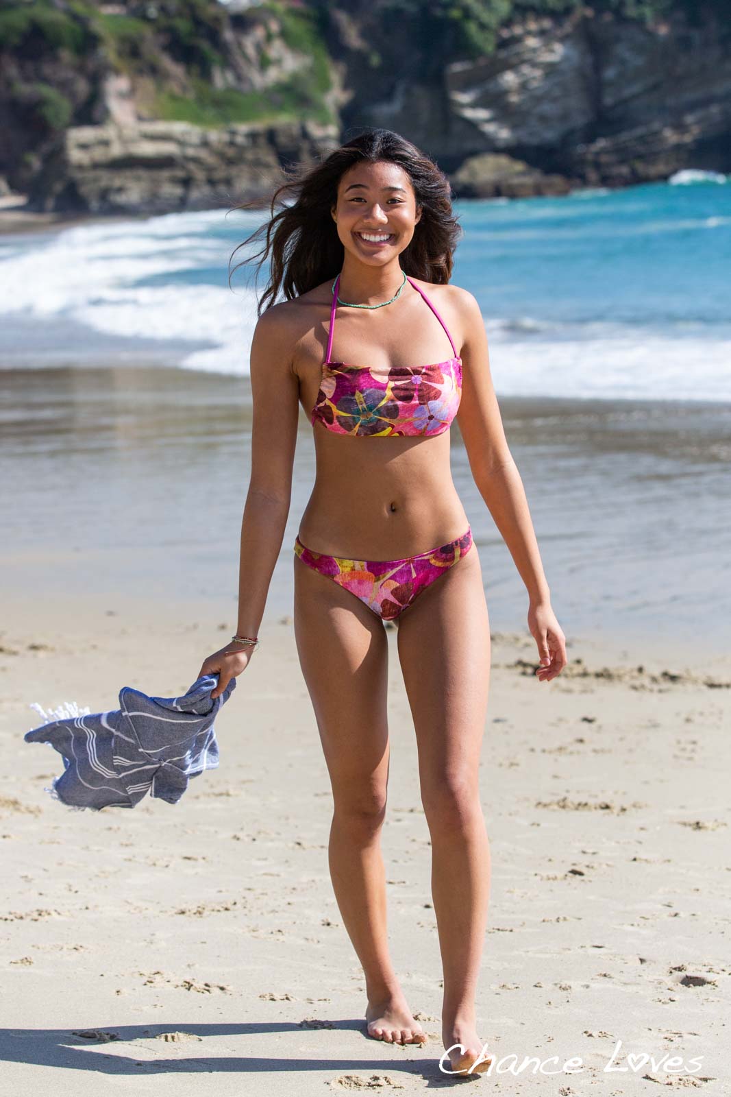 Happy teen girl beach ready walking on the sand in a beautiful colorful bikini by Chance Loves Swimwear