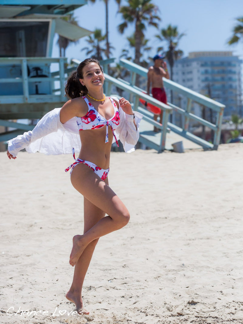 Girl dancing on the beach in her Aloha Spirit Two Piece Floral Bikini Set designed by Chance Loves Swimwear