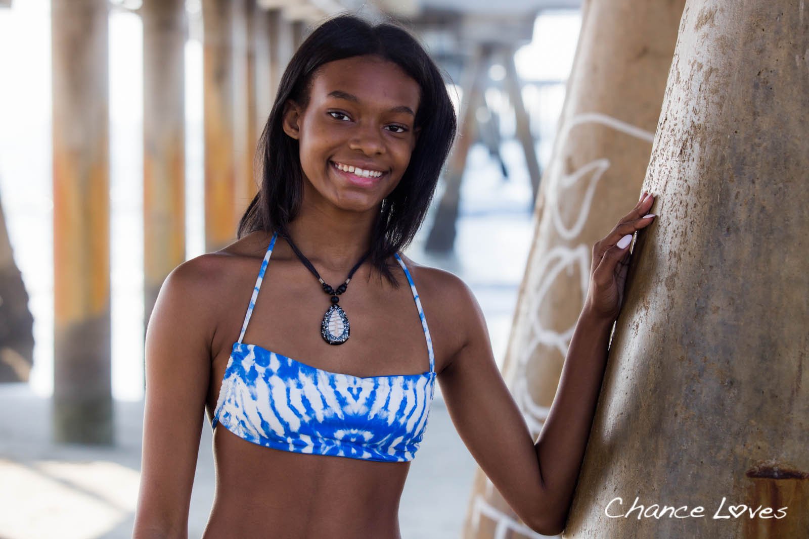 A smiling young woman on the beach in her Blue-White Reversible Bando Swim Padded Top